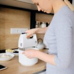 donna che prepara una ricetta utilizzando sbattitore elettrico