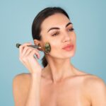 donna che si massaggia viso con rullo di giada