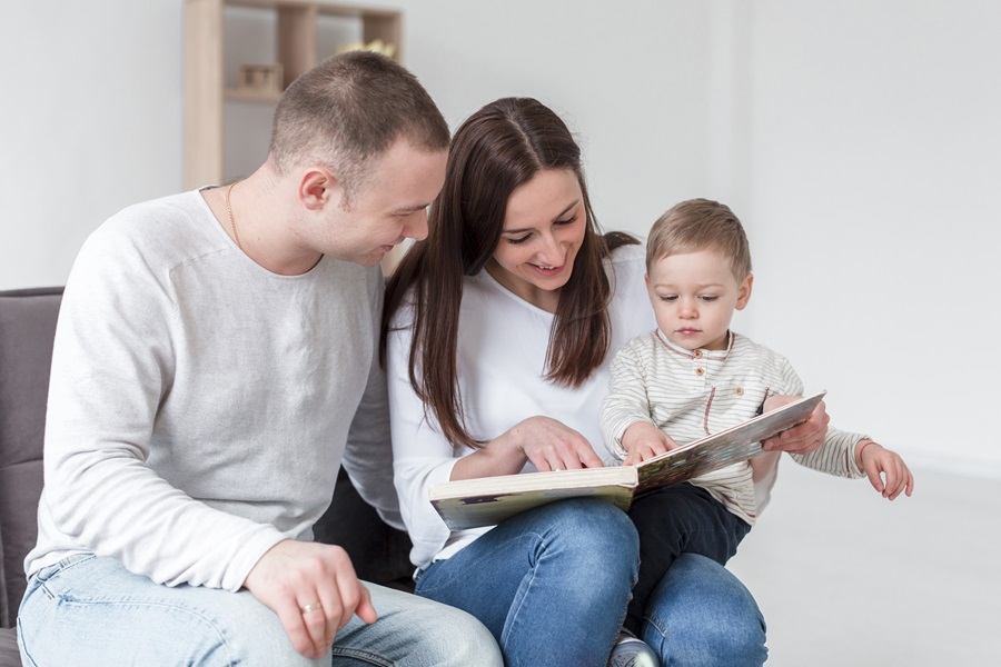 famiglia-che-legge-libro-filastrocche-natale-con-bambino-a-casa