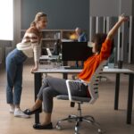donna su sedie ergonomica e un'altra in piedi ufficio