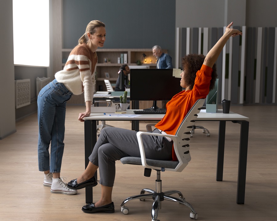 donna su sedie ergonomica e un'altra in piedi ufficio