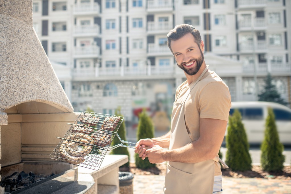 uomo che griglia al barbecue